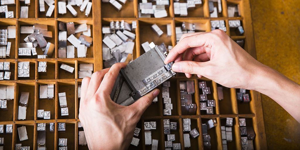 Student hands working with letterpress lead letters
